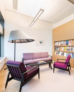 a living room filled with furniture next to a book shelf covered in lots of books