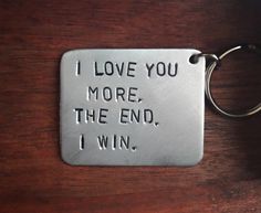 a metal keychain with the words i love you more, the end, i win on it