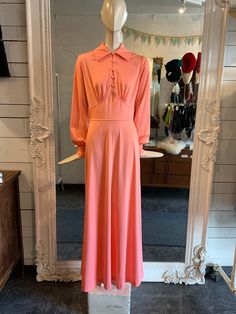 "1970s peach maxi dress- sometimes the simplest dress have the biggest impact. She is understated but elegant. There are just enough details to make this dress quite fabulous.  5 functional fabric cover buttons ru d own the front. The cuffs each have a matching button to those on the bodice. Unlined. Does up with a zipper down the back   Condition: in great condition with minor wear Label: No label Fabric Content: it has worn away, however is polyester Size on Label: 9/10 Measurements: Shoulders: 13\" Bust: 36\" Waist: 27\" Hip: 46 Length: 56.5\" Arm Opening:  16: *IMPORTANT NOTE: All measurements are taken with the garment lying flat and then doubles. Please all some wiggle room for comfort. *SALES ARE FINAL: Please make any inquiries prior to purchase." Peach Maxi Dress, Peach Maxi Dresses, Rose Maxi Dress, Seventies Fashion, 1970s Fashion, 1960s Fashion, Fabric Covered Button, Fashion History, Dress Clothes For Women