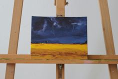 an easel with a painting on it that is being used as a canvas for a storm