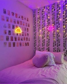 a bedroom with purple lights and pictures on the wall above the bed, along with a neon cloud