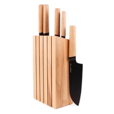 a wooden block with four knives and a black spatula in the center on a white background