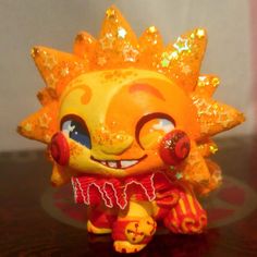 an orange and yellow figurine sitting on top of a table