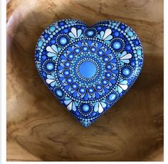 a blue heart shaped box sitting on top of a wooden table next to a piece of wood