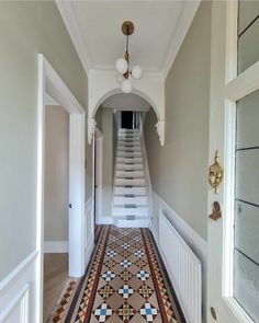 a hallway with stairs and tiled flooring