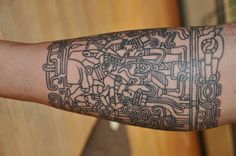 a man's arm with an intricate tattoo design on the arm and wrist area