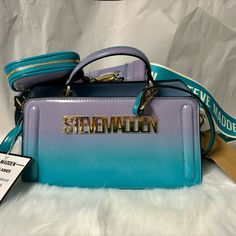 This Is A Brand New With Tag Steve Madden Teal And Purple Ombre Bevie-O Double Strap Logo Crossbody Satchel Bag With Air Pod/Coin Case. All Zippers, Clasps And Snaps Intact And Working. This Is A Smoke And Pet Free Home. Teal And Purple Ombre Bag. Steve Madden Logo Across The Front. Teal Top Handle. Gold-Tone Hardware. Double Compartments. Top Magnetic Snap Closure And Zipper Closure. Removable, Adjustable Logo, Crossbody Strap. Removable, Adjustable Teal Strap. Lined Interior With A Zipper Pock Ombre Bag, Air Pod, Crossbody Satchel, Teal Top, Steve Madden Bags, Purple Ombre, Airpods Case, Small Pouches, Blue Ombre