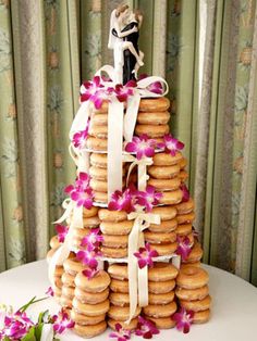 a wedding cake made out of donuts and decorated with orchids on the top