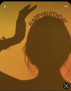 the shadow of a woman's head and hand with happy birthday written on it