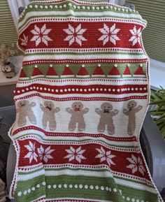 a knitted christmas blanket with bears and snowflakes