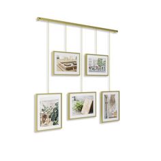 a group of pictures hanging on the side of a wall with gold frame and metal bar