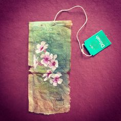 a piece of paper with flowers on it next to a tag