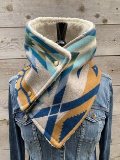 a blue and yellow scarf on top of a denim jacket