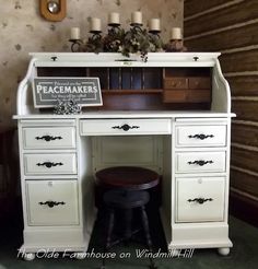 an old fashioned desk has candles on top and a sign that says peacemakers above it