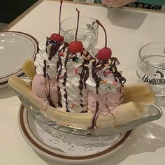 a banana split with ice cream, cherries and chocolate sauce on it sitting on a table