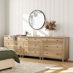 a bedroom with a bed, dresser and mirror in the corner next to a window