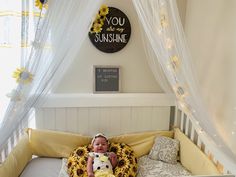 a baby sitting in a crib holding a stuffed animal