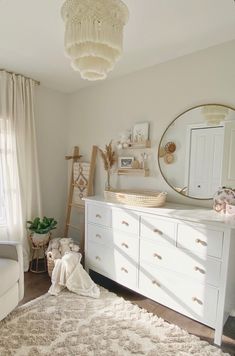 a baby's room with white furniture and decor