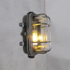 a light that is attached to the side of a white wall with yellow lights on it