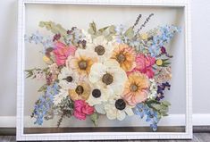 a white frame holding a bouquet of flowers