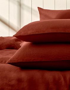 a bed topped with red sheets and pillows