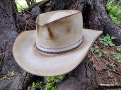 Lightly distressed western/fedora style hat. Hand blocked and shaped by me. Braided copper and cotton hat band. Calf leather inner sweatband with blue and white cotton liner.  Size is 7.  My hats are all one of a kind. I make them all myself one at a time.  The hat you see in the pictures is the exact hat you will receive. Here is a video of me making this actual hat https://www.youtube.com/shorts/Vx5ILUMB12s Let me know if you have any questions. Thanks for looking. If you would like to order a Rustic Flat Crown Hat For Ranch, Rustic Fedora With Flat Crown For Country Events, Cream Country Style Hat For Ranch, Country Style Cream Hat For Ranch, Cream Country Hat Bands For Ranch, Rustic Distressed Brown Hat Band For Country Events, Country Style Hat With Leather Sweatband For Country Events, Cream Country Style Hat Bands For Ranch, Western Cream Fedora For Country Events