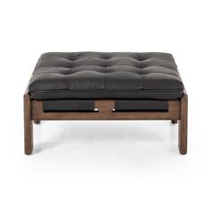 a wooden bench with black leather cushions on the top and bottom, in front of a white background