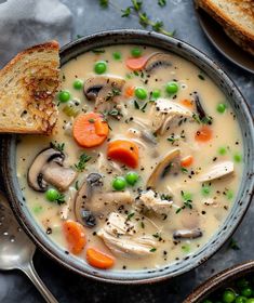 a bowl of soup with bread and peas