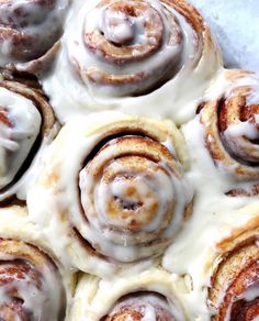 cinnamon rolls with icing sitting on top of each other