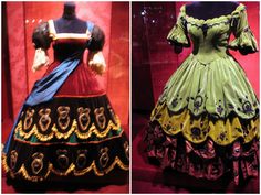 two dresses on display at a museum