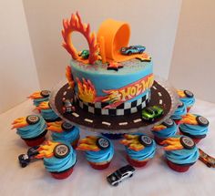 a birthday cake with cars on it and cupcakes