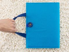 a person holding a pair of scissors on top of a blue piece of cloth