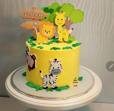 a yellow cake decorated with animals and trees