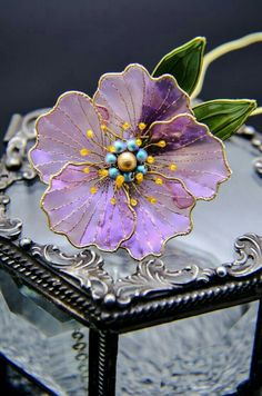 a purple flower sitting on top of a glass box