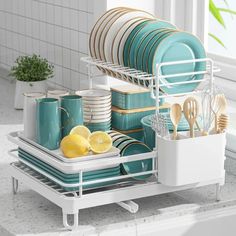 a dish rack with plates, cups and utensils