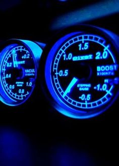 the interior of a car is lit up with blue lights and gauges on it