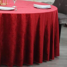 a red table cloth with white plates and silverware on it is set up for a formal function