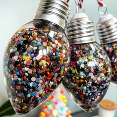 three light bulbs are filled with colorful confetti