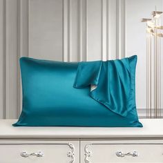 a blue pillow on top of a white dresser