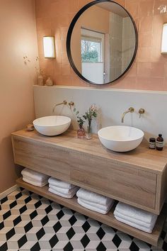 a bathroom with two sinks and a large mirror above the sink is decorated in black and white checkered floor tiles