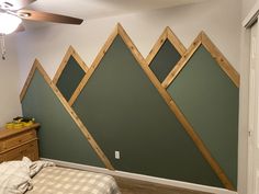 a bed room with a neatly made bed and mountains on the wall next to it