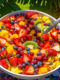 a white bowl filled with lots of fruit on top of a blue and purple table cloth