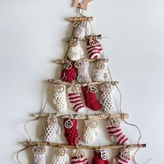 a crocheted christmas tree with stockings hanging from it's sides and stars on the top