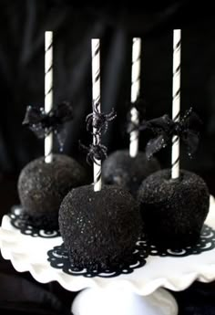 black cake pops are on a white plate