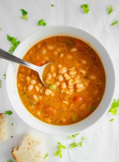 a white bowl filled with beans and bread