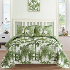 a green and white bed with palm trees on it