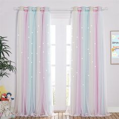 a child's room with pink, blue and white curtains