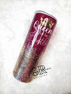 a red and gold glitter tumbler sitting on top of a white carpet with the words queen for life written on it