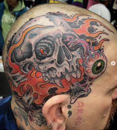 a man with a tattoo on his head has a skull in the middle of it