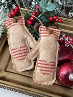 two mittens sitting on top of a tray next to christmas decorations